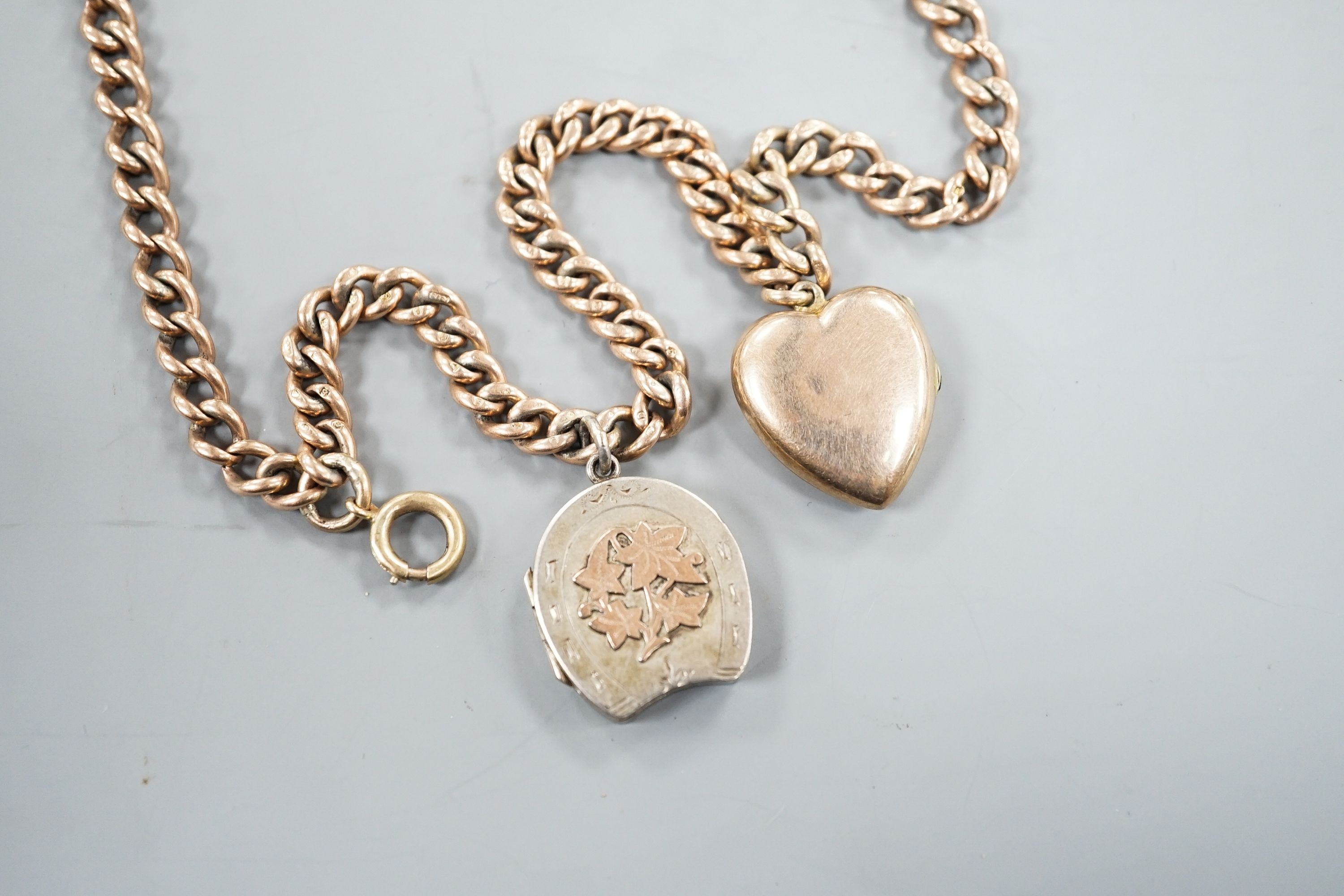 An Edwardian 9ct gold curb link chain, 44cm, hung with a yellow metal locket (gross 36 grams) and a silver locket.
